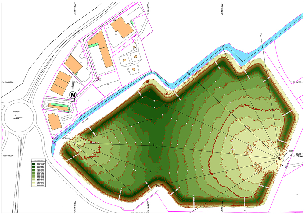 Plan topographique avec courbes de niveau d’un site de réhabilitation industrielle, montrant différents bâtiments, voiries, bassins et zones de gestion des eaux