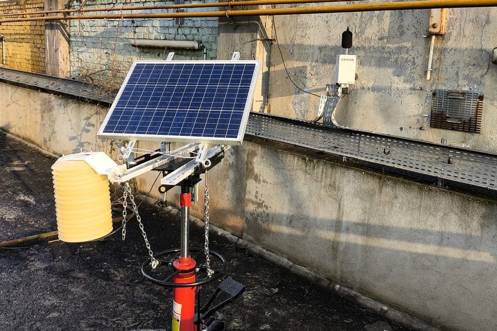Cette image repr&eacute;sente une station mobile, poussi&egrave;res et acoustique, sur tr&eacute;pied lest&eacute; et panneau solaire afin de mesurer le bruit et les &eacute;missions de poussi&egrave;res avant la d&eacute;molition.
